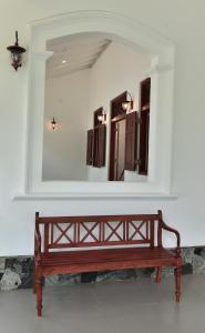 a wooden bench in a room with a mirror at Iain Lake Winds Villa in Galle