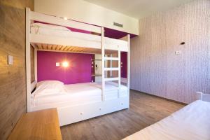 a bedroom with two bunk beds with purple walls at Hostel Link in Lovran
