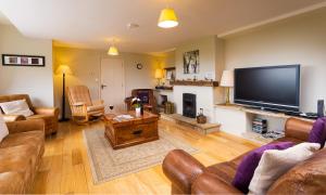 a living room with a large flat screen tv at Highbeck in Underbarrow