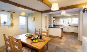a kitchen and dining room with a wooden table and chairs at Highbeck in Underbarrow