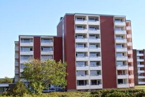 un edificio alto de ladrillo rojo con un árbol delante de él en Haus Uthlande Uthlande Whg 3 Strandliebe, en Wyk auf Föhr
