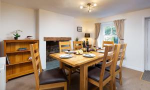 a dining room with a wooden table and chairs at Yew Tree Cottage Borrowdale in Rosthwaite