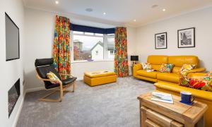 un soggiorno con divano giallo e sedia di Fell View a Keswick