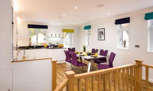 una cucina e una sala da pranzo con tavolo e sedie viola di Fell View a Keswick