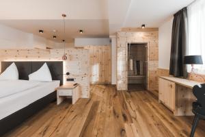 una camera con letto e parete in legno di Hotel Zum Mohren a Resia