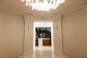 un corridoio con lampadario a braccio in una stanza di Optima Collection Khmelnytskyi a Chmel'nyc'kyj