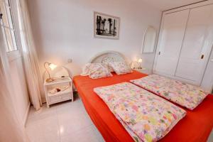 a bedroom with two beds with red sheets at Wohnung direkt am Meer in La Lajita in Lajita