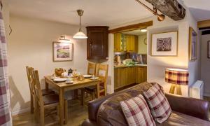a kitchen and dining room with a table and chairs at Burrow Cottage in Bowness-on-Windermere