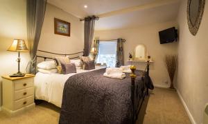 a bedroom with a large bed and a window at Burrow Cottage in Bowness-on-Windermere