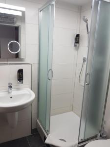 uma casa de banho com um chuveiro e um lavatório. em Hotel und Restaurant Rosenkranz em Markranstädt