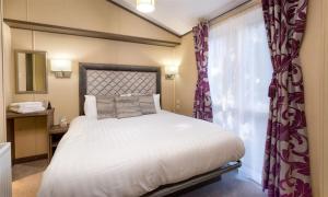 um quarto com uma cama grande e uma janela em Lancashire Rose em Windermere