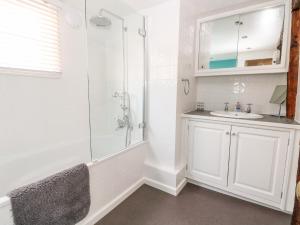 a white bathroom with a shower and a sink at Enterprise House in Bury Saint Edmunds +19 photos