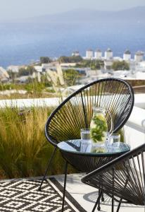 a black chair with a drink on a glass table at Epic Mykonos in Mikonos