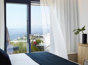una camera con letto e vista sull'oceano di Epic Mykonos a Mykonos Città