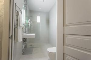 a white bathroom with a toilet and a sink at Optima Collection Khmelnytskyi in Khmelʼnytsʼkyy