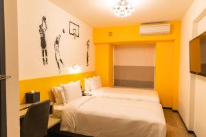 two beds in a room with yellow walls at City Inn Macau in Macau