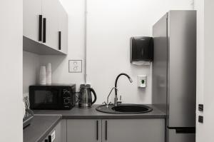 a kitchen with a sink and a refrigerator at AV-2 capsule hotel in Kyiv