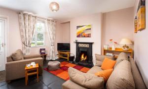 a living room with a couch and a fireplace at Dormouse Cottage in Coniston