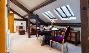 a dining room with skylights and a table with purple chairs at Hayloft in Windermere