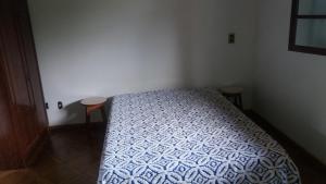 a bedroom with a bed and two stools in it at Sítio Pandoro in Atibaia