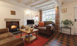 a living room with a couch and a fireplace at Smithy Cottage At Lindeth in Windermere