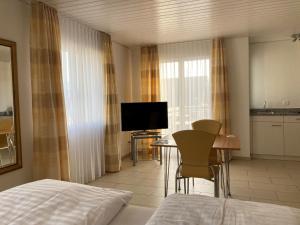 Habitación de hotel con cama, mesa y TV en Landgasthof Krone Bed & Breakfast, en Sankt Gallenkappel