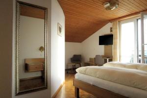 1 dormitorio con 2 camas y espejo en Landgasthof Krone Bed & Breakfast, en Sankt Gallenkappel