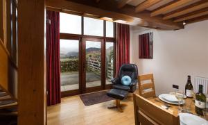 a living room with a chair and a table and a window at Nest Barn in Keswick