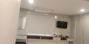 Habitación blanca con TV y pared blanca en PPH Living Silver Villa 2, en Visakhapatnam
