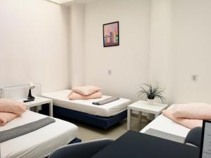 a room with three beds with pink pillows on them at Rynek 7 in Katowice