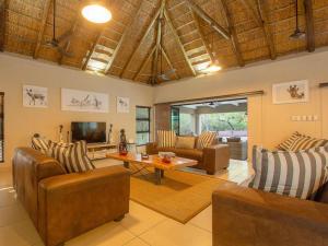 a living room with leather furniture and a television at The Den at Kruger 3479 in Marloth Park