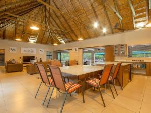 uma grande cozinha com uma grande mesa de madeira e cadeiras em The Den at Kruger 3479 em Marloth Park