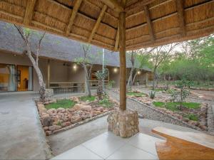 einem Pavillon mit einer Bank in der Mitte eines Gartens in der Unterkunft The Den at Kruger 3479 in Marloth Park