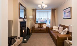 a living room with a couch and a fireplace at Noble Cottage in Keswick