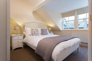 a bedroom with a white bed and a window at Noble Cottage in Keswick