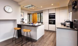 a kitchen with a counter with stools and a clock at Foxrock in Windermere