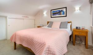 a bedroom with a bed with a pink blanket at Foxrock in Windermere