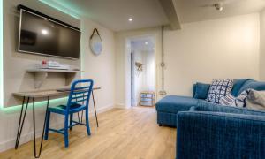 a living room with a blue couch and a table at Foxrock in Windermere