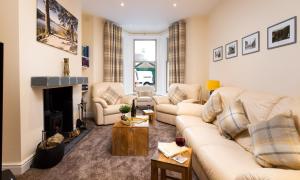 a living room with two couches and a fireplace at Dovedale in Keswick