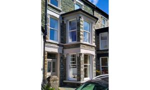 a house with white windows and a car parked in front at Dovedale in Keswick