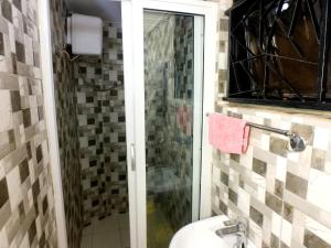 ein Bad mit einem WC und einer Glasdusche in der Unterkunft Studio Ghibli 1BR1B in Kampala