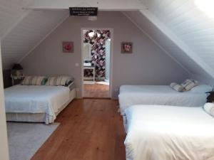 two beds in a room with a attic at Les chambres de Marie in Le Saint