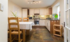 a kitchen with a table and chairs in a room at Woodside West in Bowness-on-Windermere