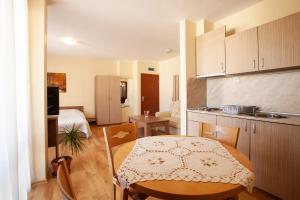 a kitchen with a table and a room with a bed at Guest House Ela in Bansko