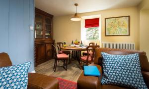 a living room with a table and a dining room at South Stonethwaite Cottage in Windermere