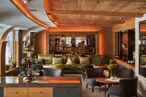 a hotel lobby with couches and tables at Hotel Auriga in Lech am Arlberg