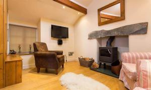 a living room with a wood stove and a chair at Ivy Cottage in Ambleside