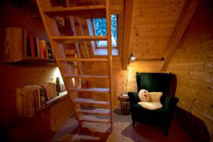a stairway in a room with a green chair at Naturparkhütte Mandl in Sankt Lambrecht