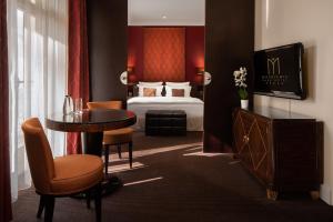 シュツァブニツァにあるModrzewie Park Hotel & SPAのベッド、テーブル、椅子が備わるホテルルームです。
