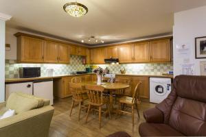 cocina con mesa, sillas y sofá en Gilpin View en Crosthwaite